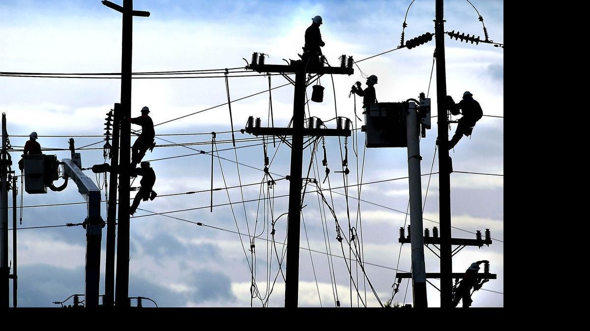 
PG&E workers work on power lines in Bakersfield, Calif. On Friday, the Public Utilities Commission voted 5-0 to approve the most significant restructuring of electricity rates since the Legislature froze rates for many customers during the 2001 energy crisis.
