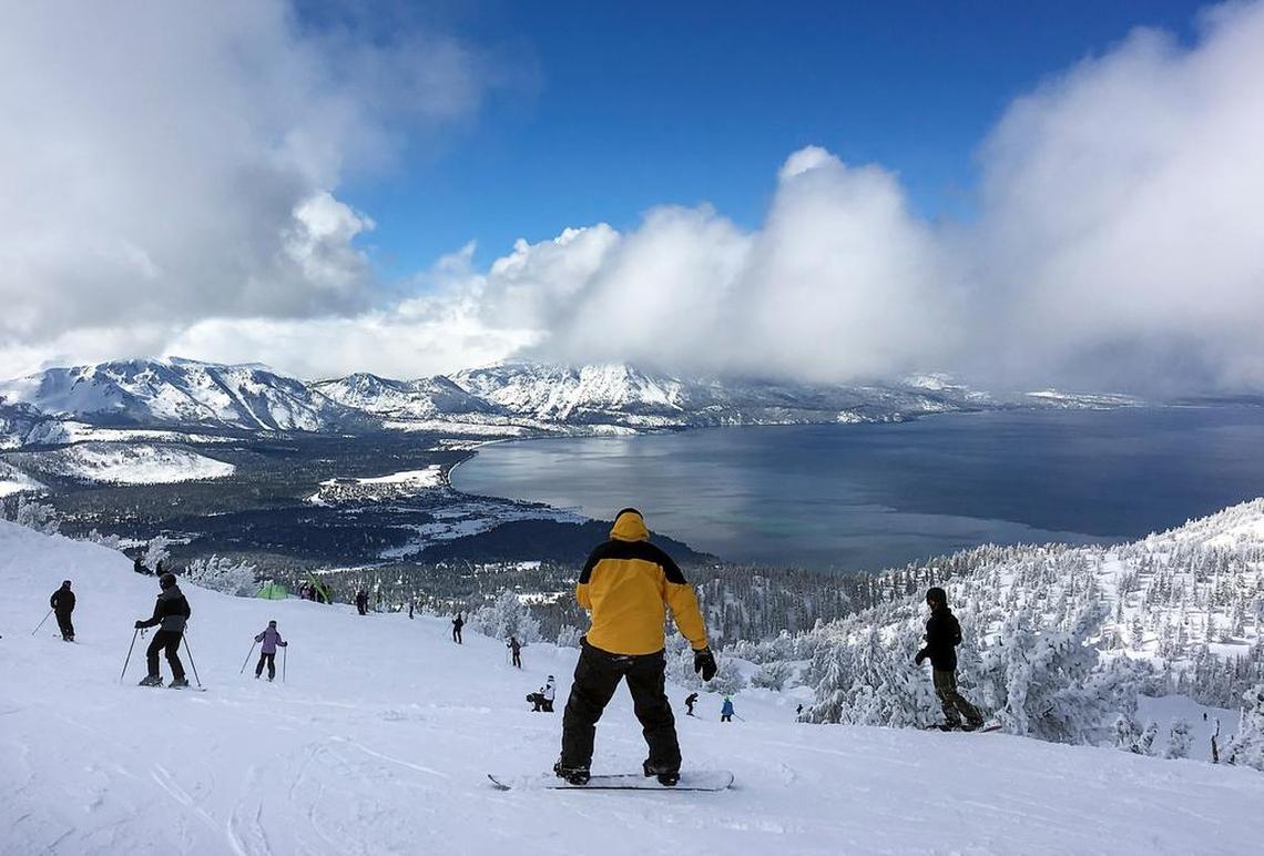 Skiers and a snowboarder see a stunning panorama of Lake Tahoe at Heavenly Ski Resort on Thursday. Heavenly’s owner, Vail Resorts of Colorado, said this is the snowiest winter the Tahoe area has seen in 22 years. Heavenly, Kirkwood and Northstar will stay open into April.