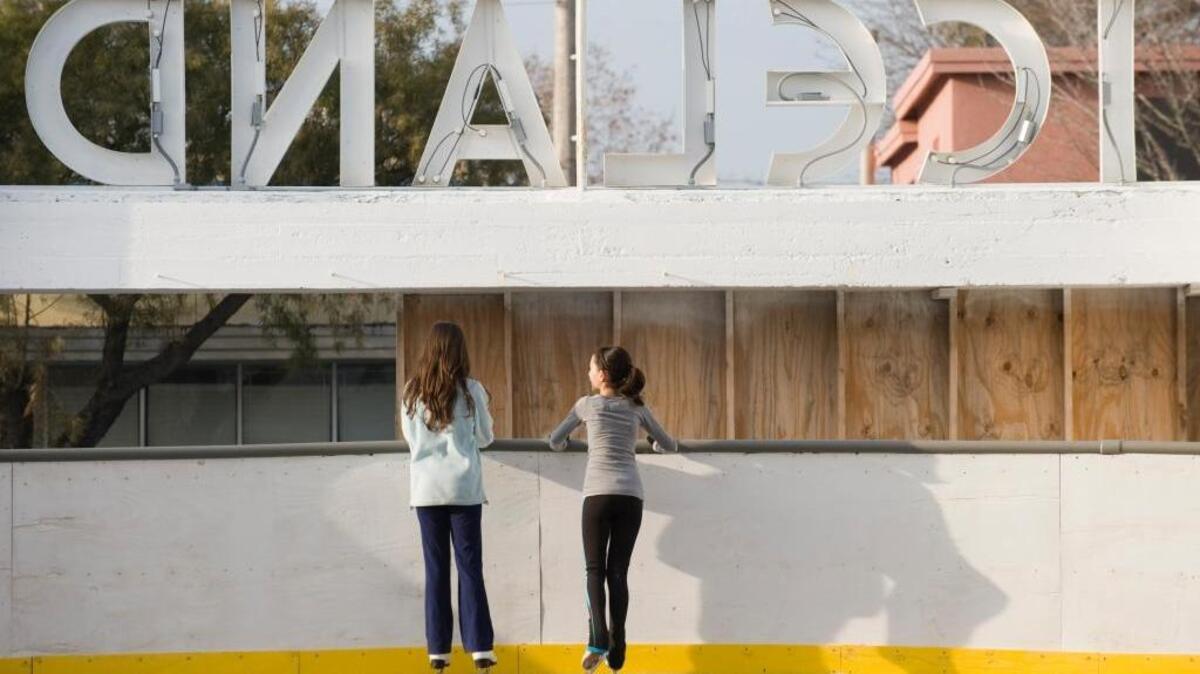 Two skaters catch up in January 2011 at the Iceland Ice Skating Rink, which burned in March 2010, on the first day it opened without a roof. The Sacramento City Council on Tuesday approved loans to restore the facility and install a new roof.