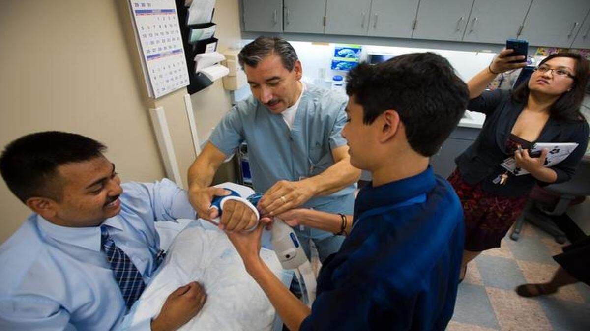Kaiser Permanente senior orthopedic technician Luis Moncayo helps high school senior Ayush Kumar, 18, at right, cut a cast on Melvin Sem, 16, during an intern program for high school students at Kaiser's South Sacramento facility in 2012. Kaiser south and Sutter Medical Group both received high marks in an assessment fro Consumer Reports.
