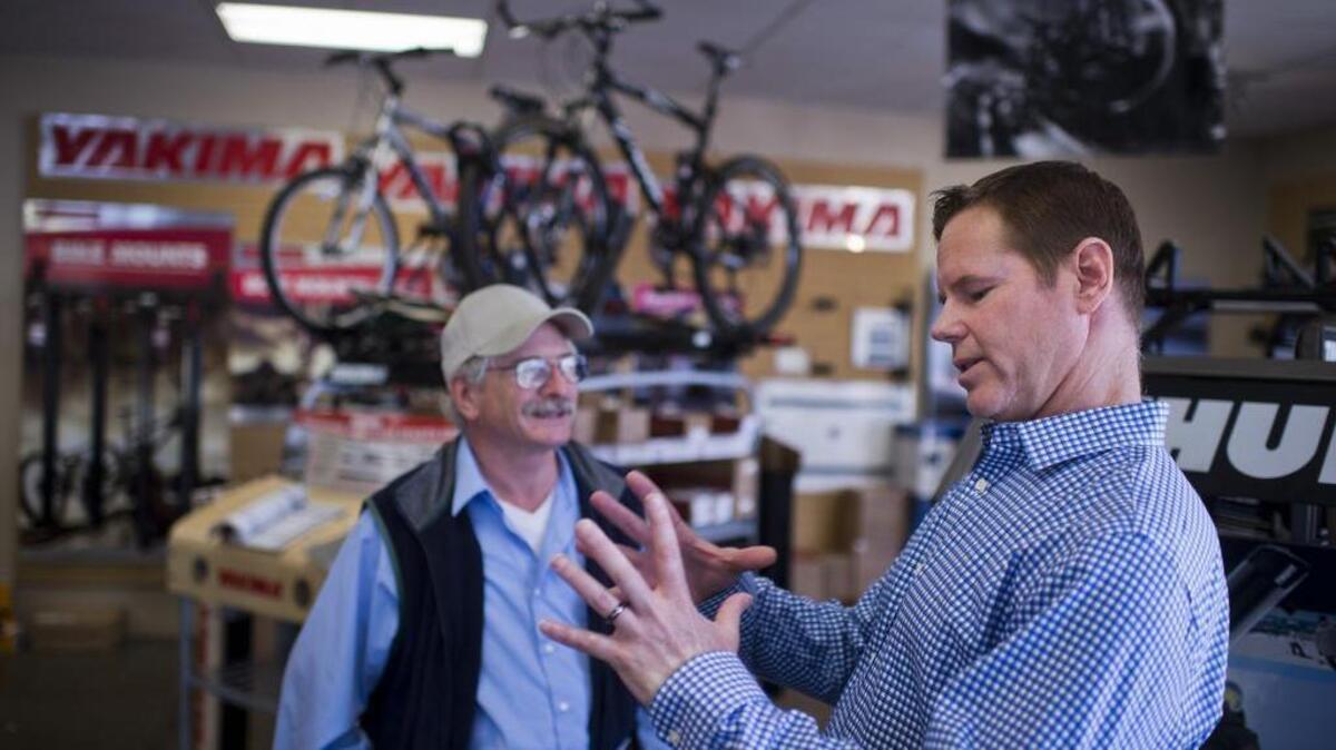 Rack N Road founder and majority owner Greg Bauer, right, chats with customer Ken Nead at the Arden Way store in Sacramento in 2014.