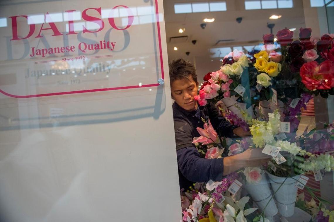 Bon Jovi Casilang, corporate assistant manager at Daiso Japan in Roseville, arranges bouquets of imitation flowers on Tuesday, March 8, 2016.