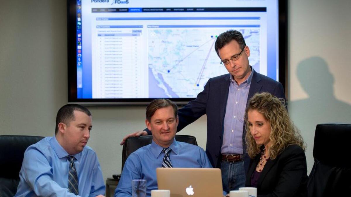 Pondera Solutions CEO Jon Coss, standing, confers last week with, from left, Tom Lucero, vice president of development; Greg Loos, chief operating officer; and Amanda Huston, vice president of service delivery, at the company’s Gold River offices.