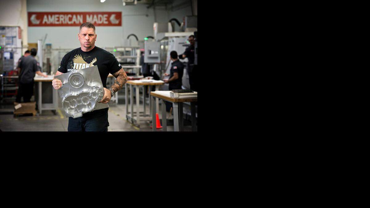 
Titan Gilroy on Thursday holds a machined part for an electric car company in Oregon that would take several hours to make that his company makes in 45 minutes. Gilroy’s machine shop in Grass Valley is about to become part of a new television series.
