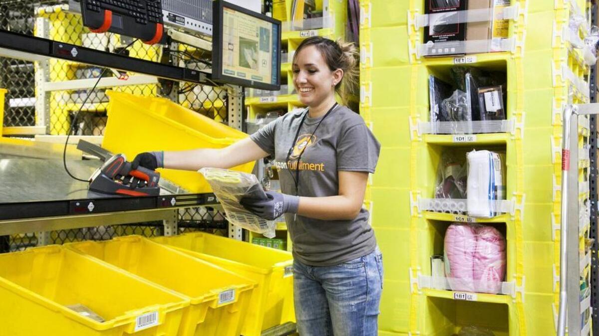 
An Amazon.com employee at the company’s distribution center in Tracy “picks” orders via a hand-held device.

