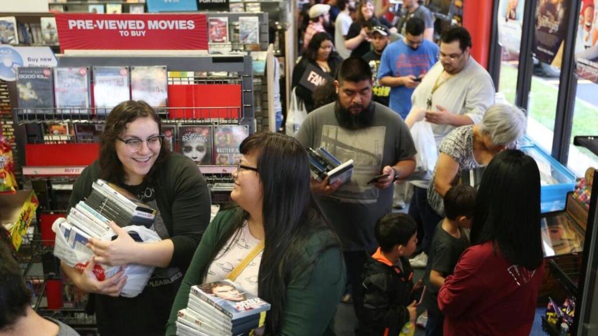 Denise Rodriguez, left, and Erica Martinez wait in a long line to purchase movies during the liquidation process of the last Blockbuster location in Texas Saturday, Jan. 27, 2018, in Edinburg, Texas. Martinez says she and Rodriguez still rented from the store because the internet in her part of Hidalgo County is not fast enough to stream movies online. The location was the last to remain open in the state of Texas, in which Blockbuster opened its' first store in Dallas in 1985.