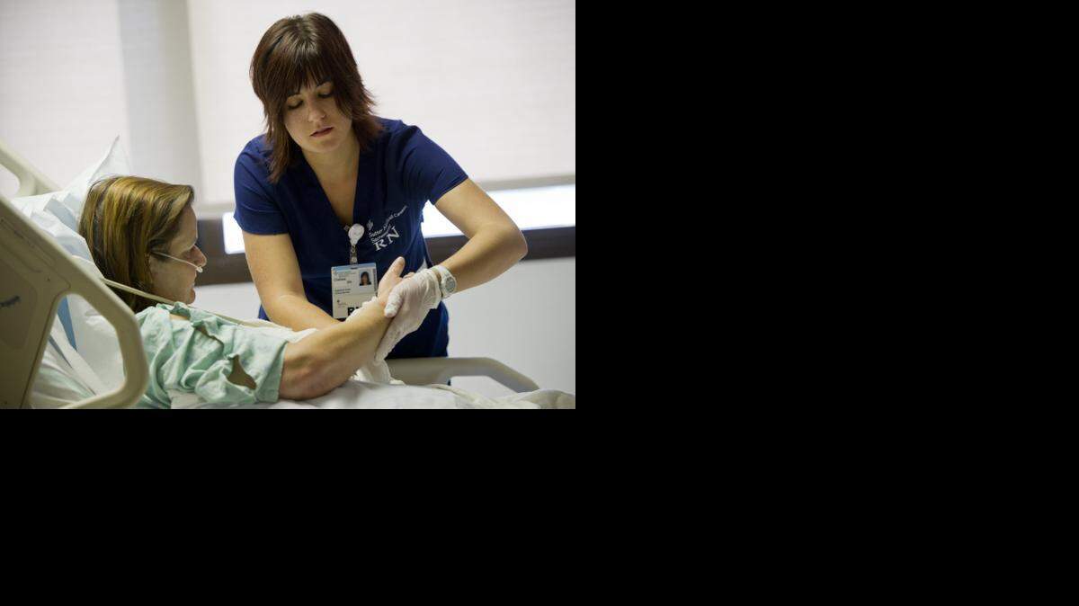 
Chelsea Hallford, a nurse at Sutter Memorial, checks in on patient Britta Sharpe on the cardiac ward Friday, Sept. 12, 2014. 
