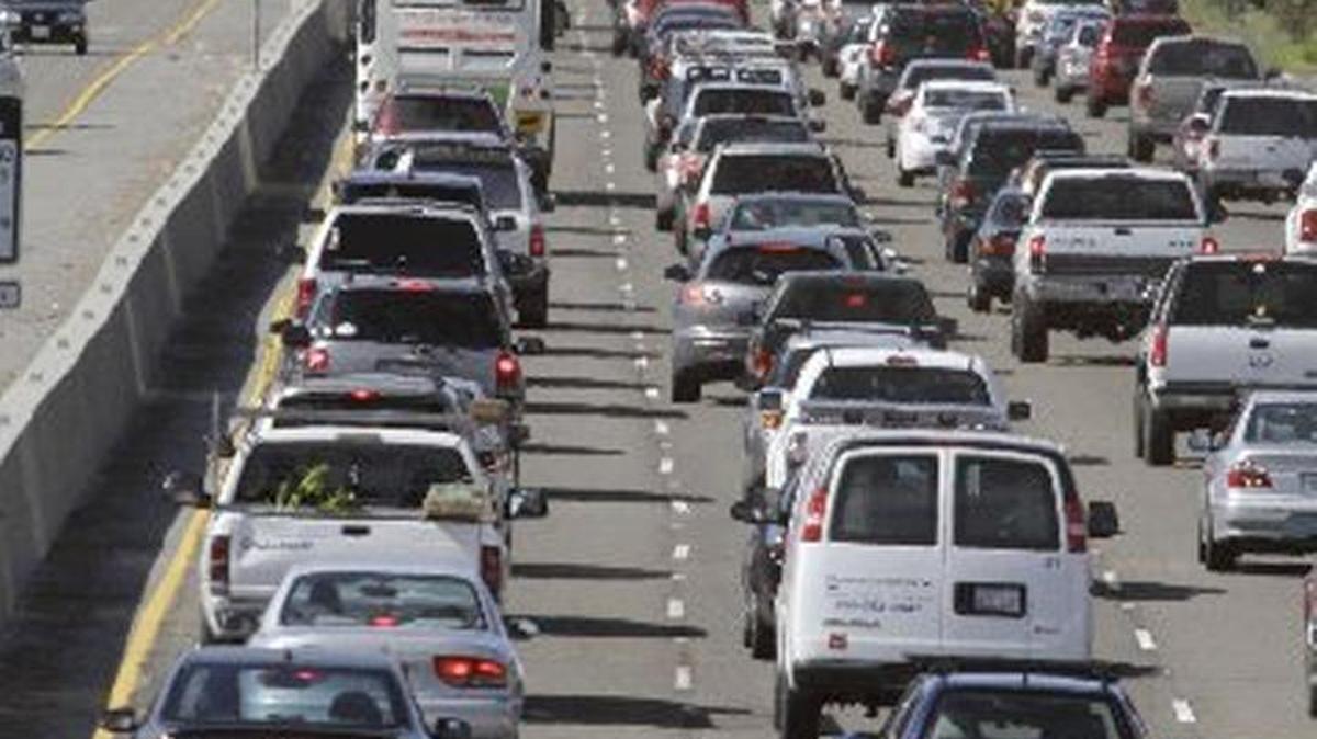 A motorcyclist rides between lanes as traffic backs up on U.S. 101 in Mill Valley, Calif., in 2011. A report released Thursday, Oct., 28, 2016, estimates that petroleum-based fuels cost California about $15 billion a year.