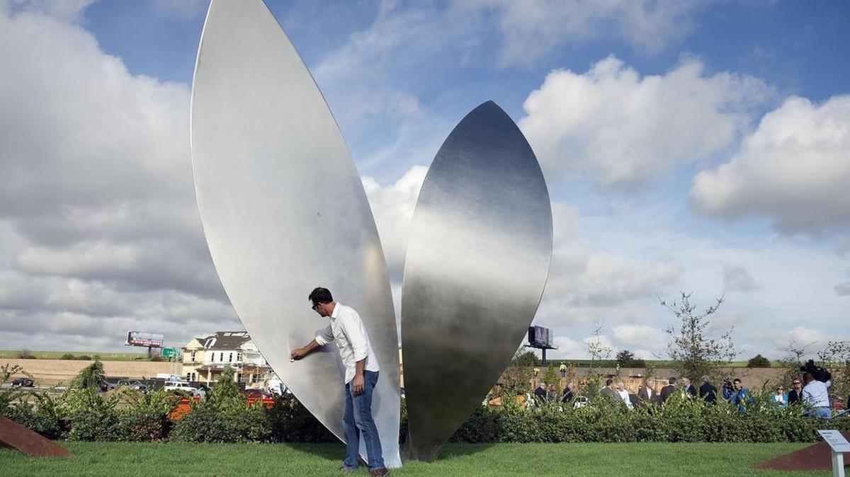 Artist Marc Foster of East Sacramento wipes off a part of his art piece, “La Feuille,” made of stainless and corten steel, before the dedication of Alan and Helen Post Park on Monday, October 31, 2016 in Sacramento, Calif. City officials and community members gathered for the dedication of the recently completed park, the City of Sacramento's newest urban park - in the new McKinley Village neighborhood in East Sacramento.