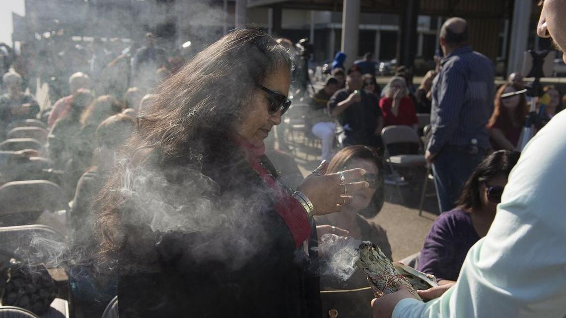 Mary Tarango, the first official Wilton Rancheria chairwoman, is surrounded by sage smoke – to bless the area, people and ground around them – before the start of a news conference at the site of a never-finished mall.