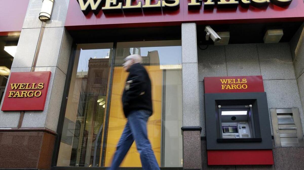 FILE - In this Wednesday, Dec. 19, 2012, file photo, a man walks past a Wells Fargo location in Philadelphia. Wells Fargo reports quarterly financial results on Friday, July 11, 2014.