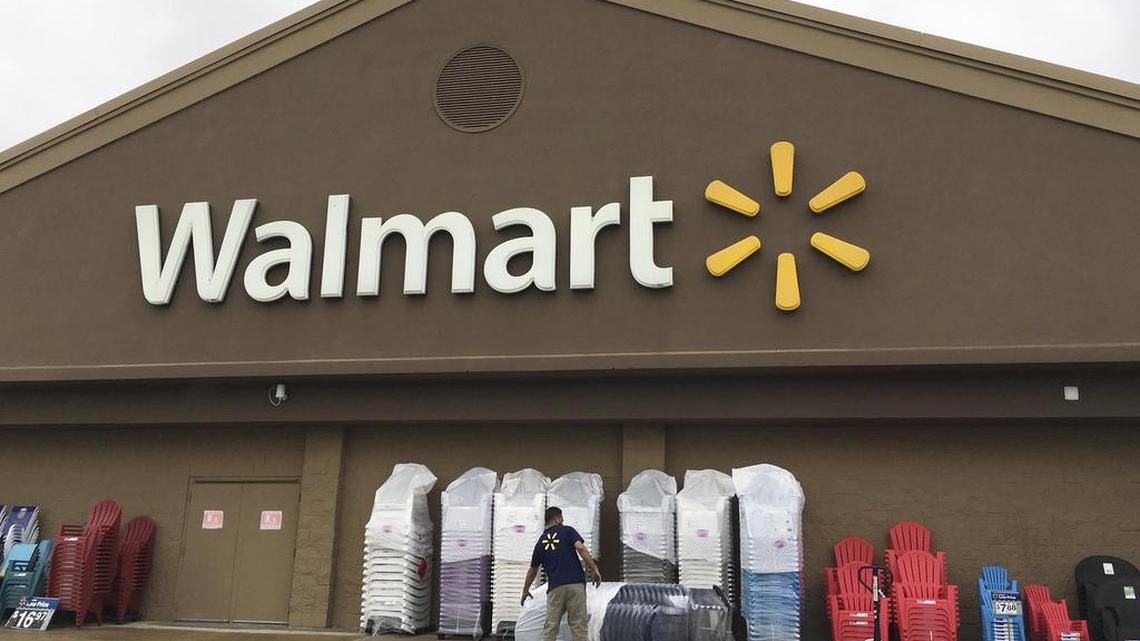 FILE - In this June 5, 2017, file photo, a worker stacks merchandise outside a Walmart in Salem, N.H.