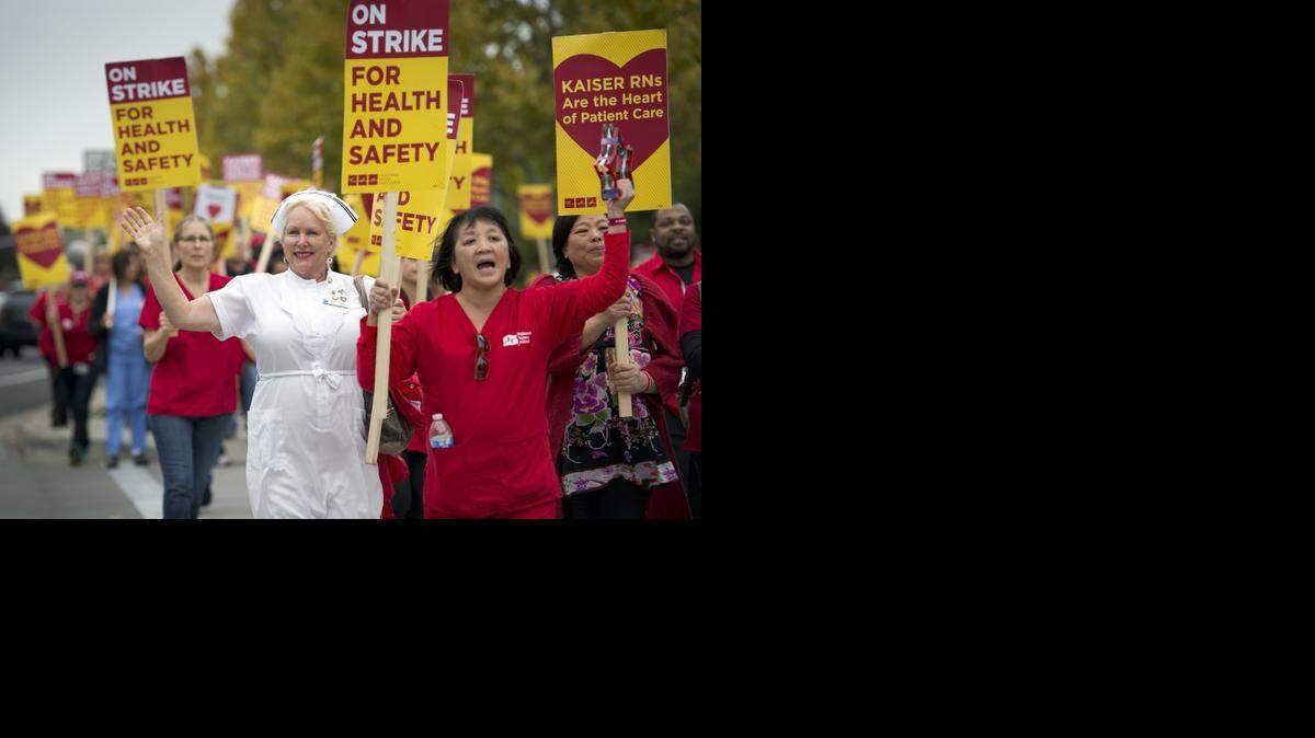 Wendy Fischer, wearing a white nurse outfit, has been a Kaiser nurse for 34 1/2 years and walks with striking Kaiser nurses around the perimeter of Kaiser Roseville on November 11, 2014 in Roseville, Calif.