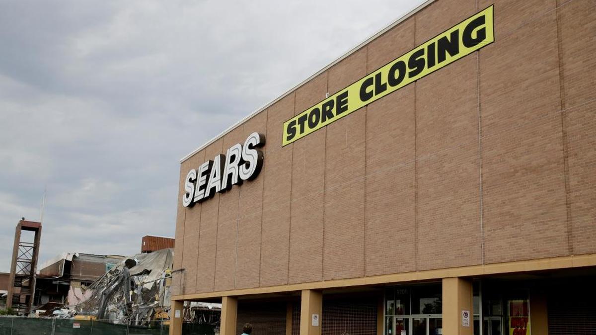 A Sears store slated for closing stands alongside a mall that is being torn down July 8, 2017, in Overland Park, Kan. The company announced Thursday that more than 100 Sears and Kmart stores will close by early April.