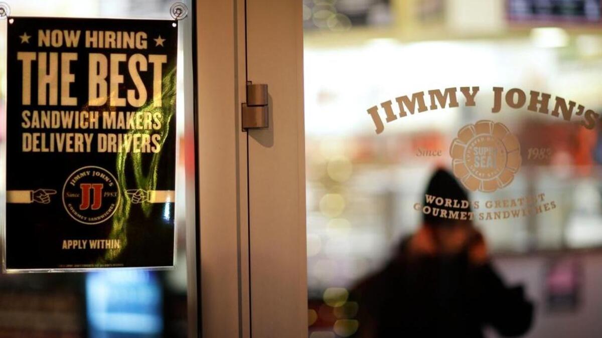 FILE -- A sign advertises hiring opportunities at a Jimmy Johns sandwich shop, as an employee walks out to make a delivery, Friday, Jan. 2, 2015, in Atlanta. Jimmy John’s recently opened its fifth location in the Sacramento area.