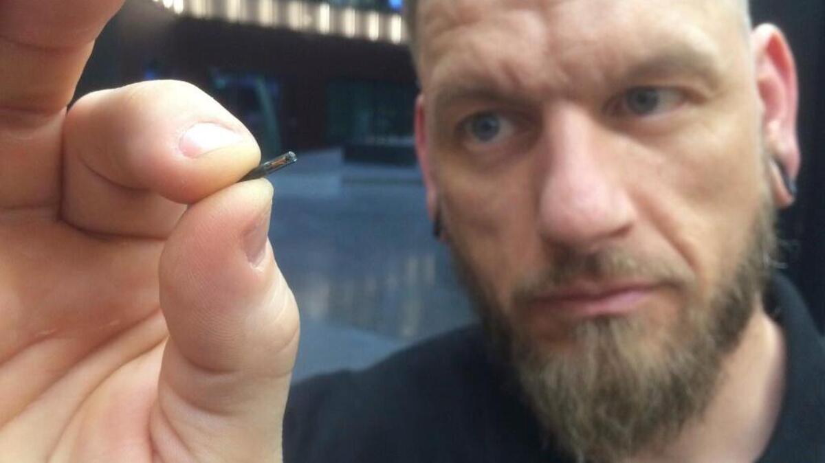 Self-described body hackerâJowan Osterlund from Biohax Sweden, holds a small microchip implant, similar to those implanted into workers at the Epicenter digital innovation business centre during a party at the co-working space in central Stockholm, Tuesday March 14, 2017. Microchips are being implanted into volunteers to help them open doors and operate office equipment, and its become so popular that members of the Epicentre cyborg club hold regular parties for those with the tiny chips embedded in their hands.
