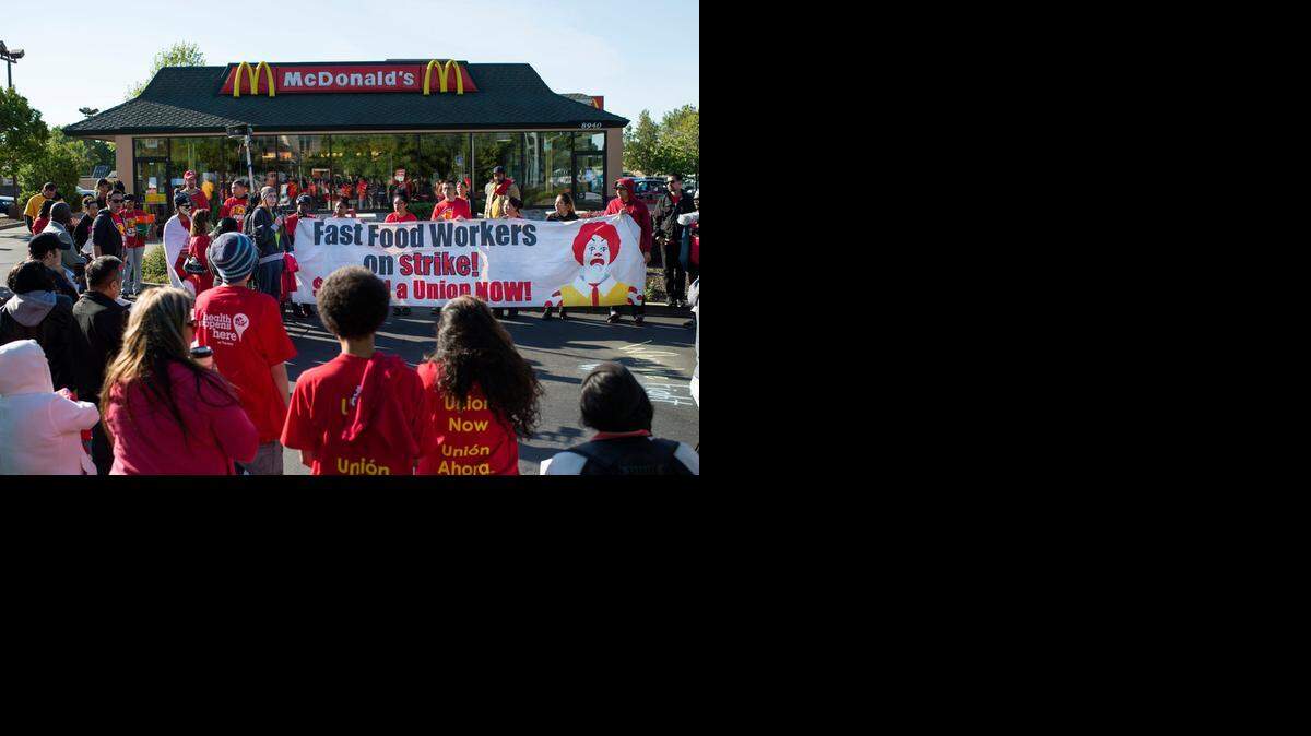 
A rally, part of a nationwide campaign for raising the minimum wage, uses a McDonald’s in the Pocket area as a backdrop for its call to set a $15 wage. 
