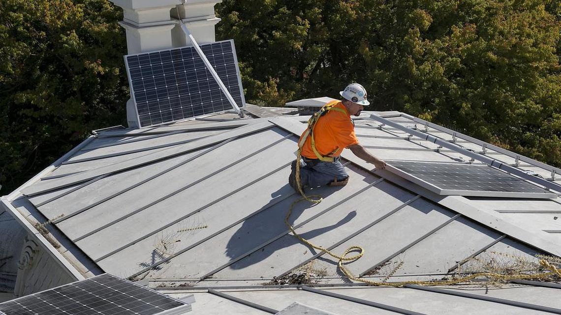 Workmen install solar panels on the roof at the historic Governor's Mansion in Sacramento on Friday, October 16, 2015.