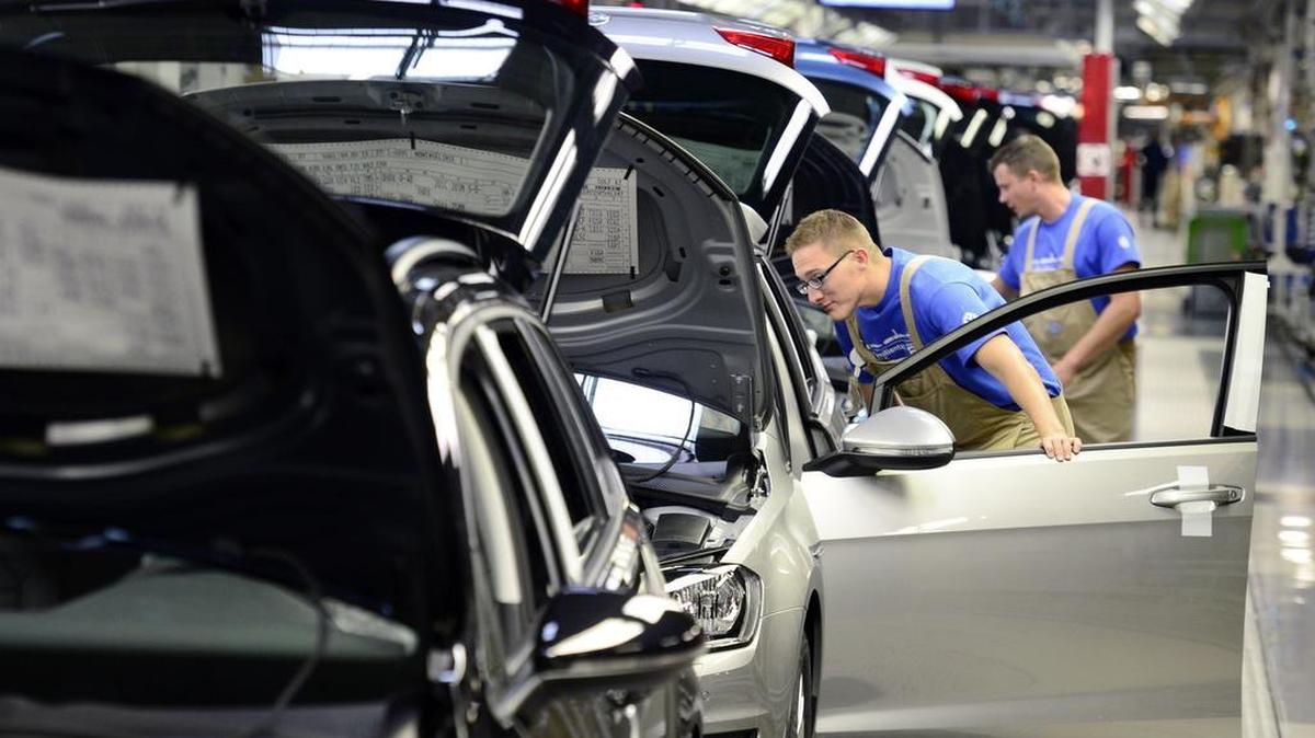 Workers complete cars at the assembly line during the so called ‘Open Door Day’ to celebrate the 25th anniversary of the plant of the German manufacturer Volkswagen Sachsen in Zwickau, eastern Germany, Sunday, Sept. 6, 2015. More than 4.9 Million vehicles (Golf and Passat) have left the production facilities since foundation on the Zwickau plant in 1990. (AP Photo/Jens Meyer)
