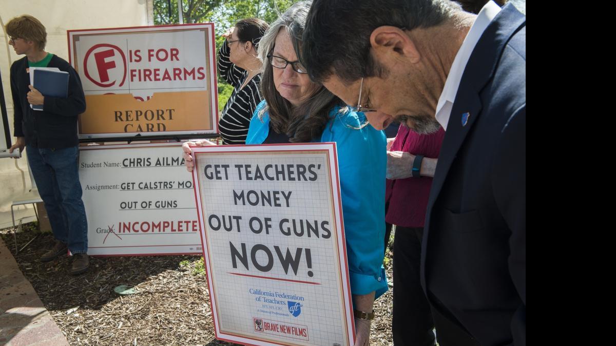 
Members of the California Federation of Teachers participate in a moment of silence as they protest outside a board meeting at CalSTRS headquarters over continued firearms investments on April 2 in West Sacramento. From left are Bill Miller, Linda Sneed, Joanna Valentine and Fred Glass.
