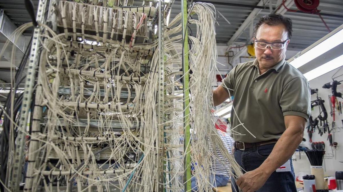 Hieu Ly, an electrical assembler for Siemens, wires a light rail vehicle at the company’s south Sacramento plant in October 2015.