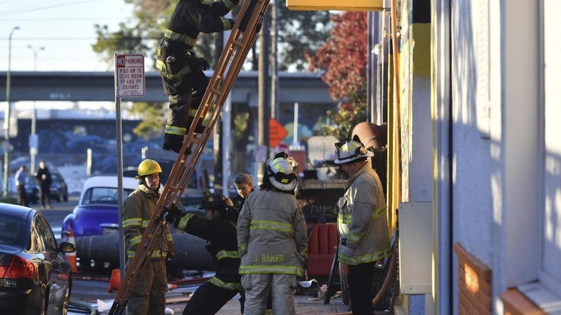 Firefighters on Saturday assess the scene where a fire tore through a warehouse party late Friday, Dec. 2, 2016.