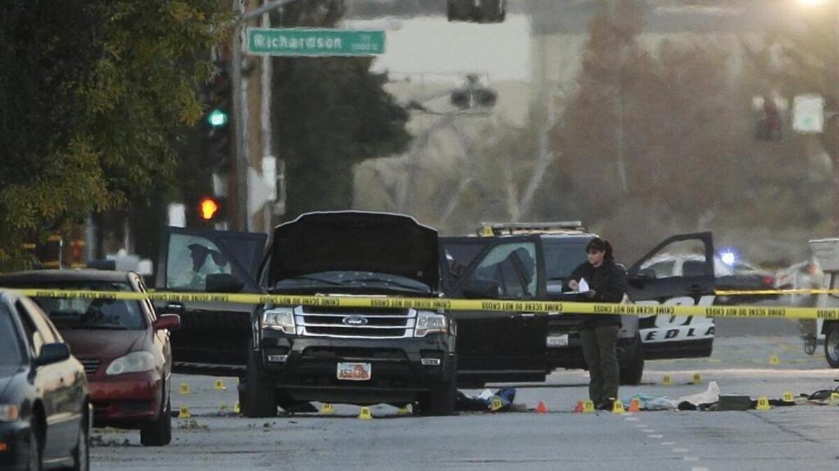 An investigator looks at a Black SUV that was involved in a police shootout with suspects, Thursday, Dec. 3, 2015, in San Bernardino, Calif. A heavily armed man and woman opened fire Wednesday on a holiday banquet, killing multiple people and seriously wounding others in a precision assault, authorities said. Hours later, they died in a shootout with police.