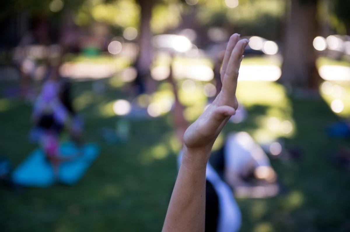 A woman extends her arm into the air at Yoga in Park at Fremont Park in 2017.