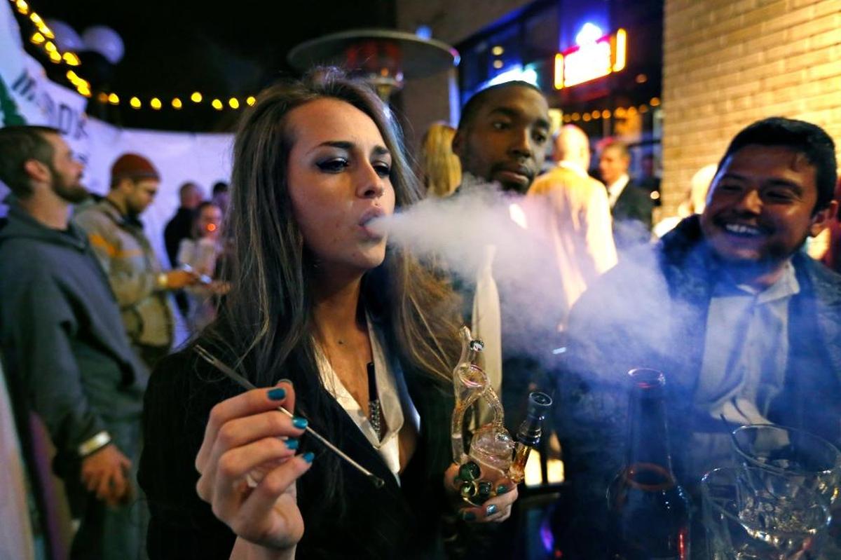 Partygoers smoke marijuana in Denver.