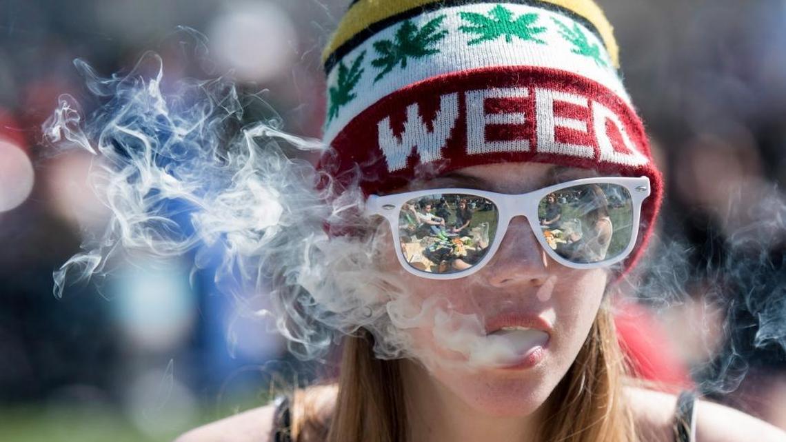 A woman exhales while smoking marijuana during the annual 420 marijuana rally on Parliament Hill in Ottawa, Canada, Wednesday, April 20, 2016.