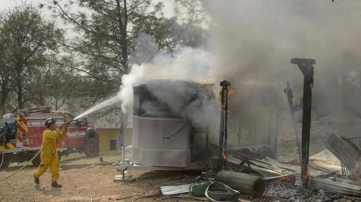 Firefighters extinguish a fire in a horse trailer on a property along Lone Tree Road near Loma Rica on Oct. 10.