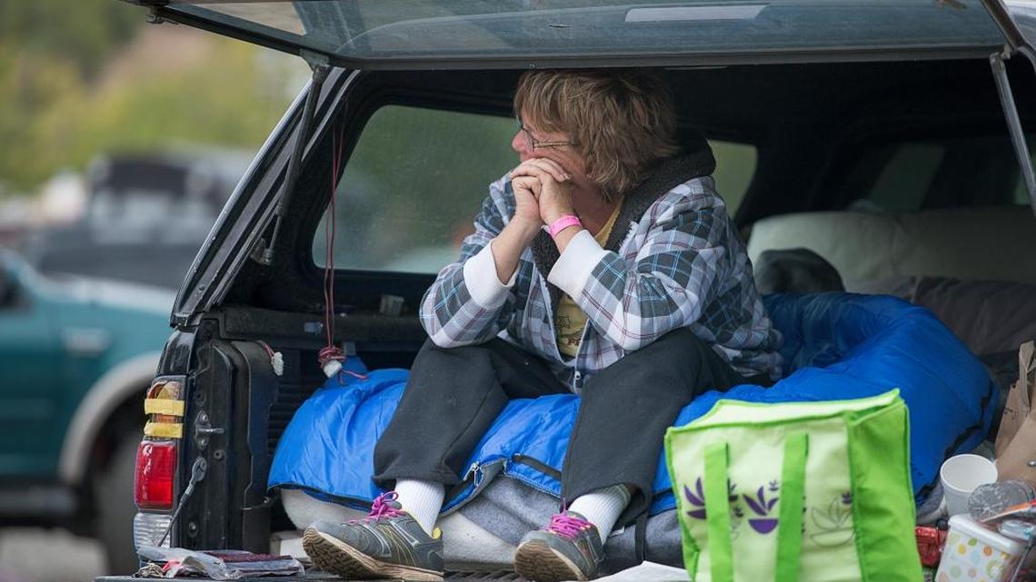 
Angie Lemmon, 52, of Hidden Valley Lake sits in the back of her truck at a temporary shelter set up since Saturday at the Clear Lake Oaks Moose Lodge 2284 on Wednesday, Sept. 16, 2015, in Lake County. She escaped the flames with some clothing and her dogs as the fire approached her home. 
