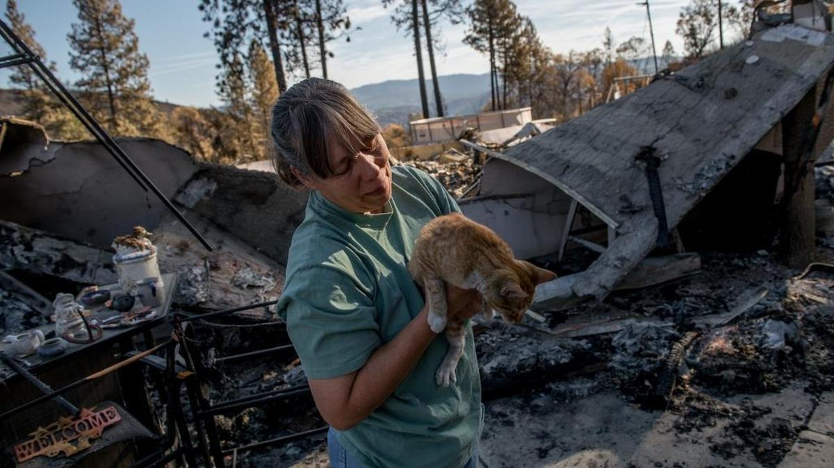 
Butte fire victim Jacki Malvini, with her cat Pumpkin on their burned-out property, is determined to recover from the Butte fire because she has survived fire before. “It is going to all come back,” she says of her town.
