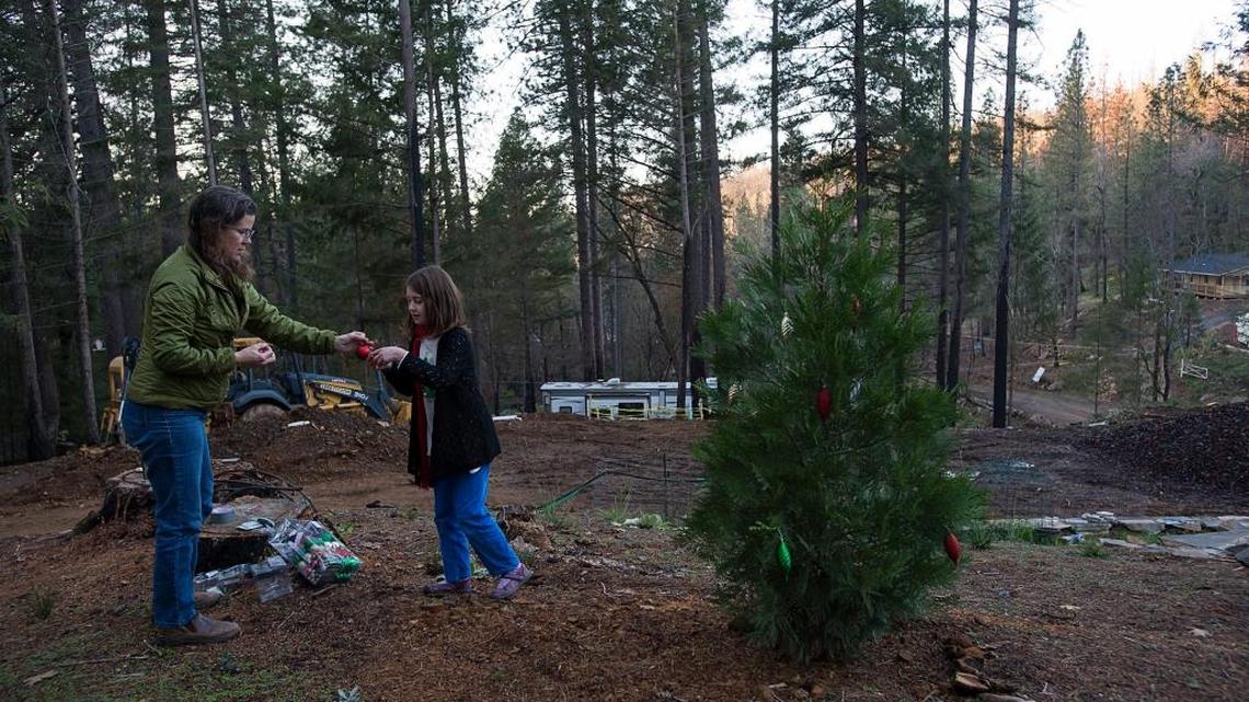 Cindy and Maya Leonard put decorations on a small tree growing on their Cobb Mountain property, which was scorched during the devastating 2015 Valley Fire. Residents say a guarded sense of optimism is returning to the Lake County community as it rebuilds itself.