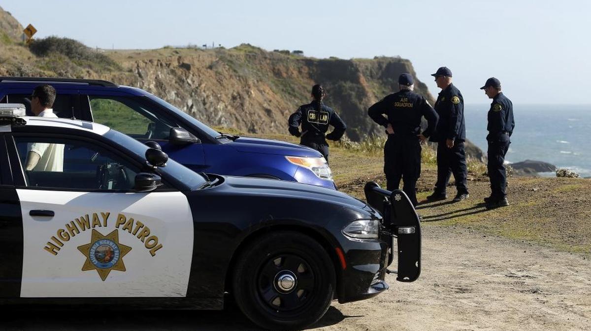 California Highway Patrol officers and deputy sheriffs from Mendocino and Alameda counties gather after a search for three missing children Wednesday, March 28, 2018, at the site where the bodies of Jennifer and Sarah Hart and three of their adopted children were recovered two days earlier, after the family's SUV plunged over a cliff at a pullout on the Pacific Coast Highway near Westport, Calif. Three of the children, Devonte Hart, 15, Hannah Hart, 16, and Sierra Hart, 12, have not been found.