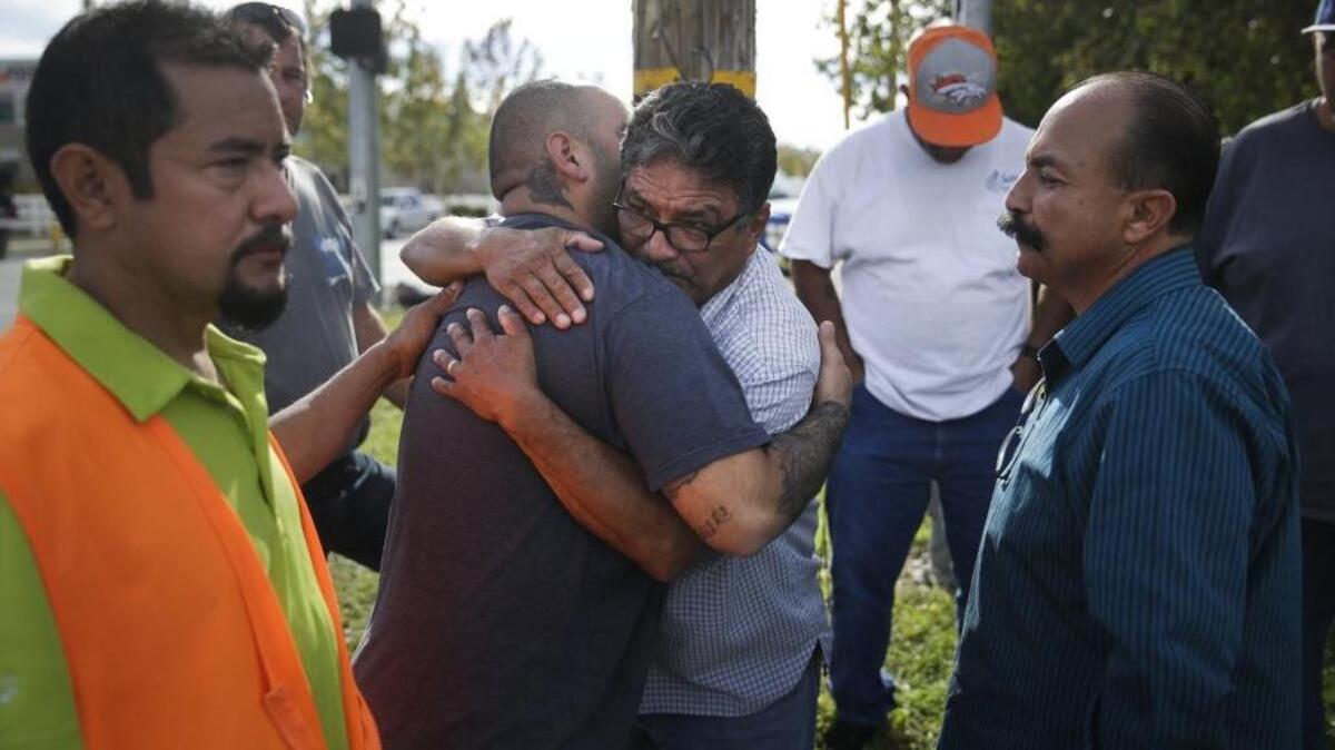 Jesus Gonzales, center left, is comforted by local church members including Jose Gomez, center right, Thursday, Dec. 3, 2015, in San Bernardino, Calif. Gonzales had been unable to get to his home due to a police shootout with suspects which took place in his neighborhood.