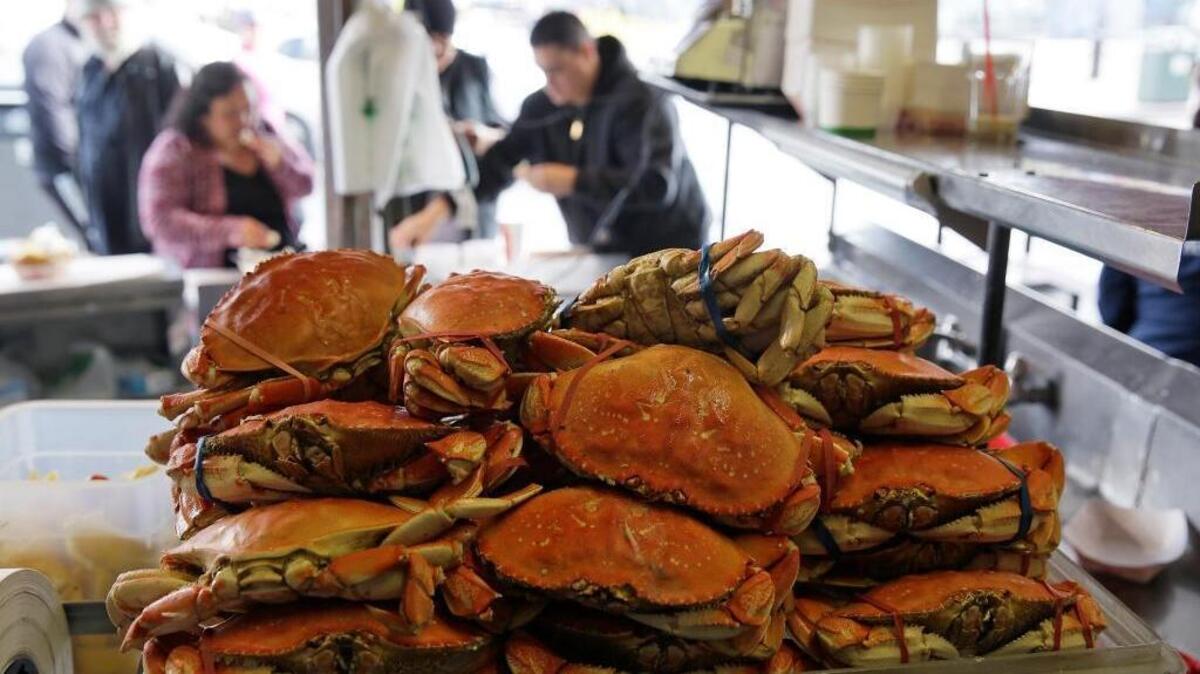 A stack of imported Dungeness crabs are shown for sale as people eat them in the background at Fisherman's Wharf Tuesday, Dec. 22, 2015, in San Francisco. California's Dungeness crab season remains closed.