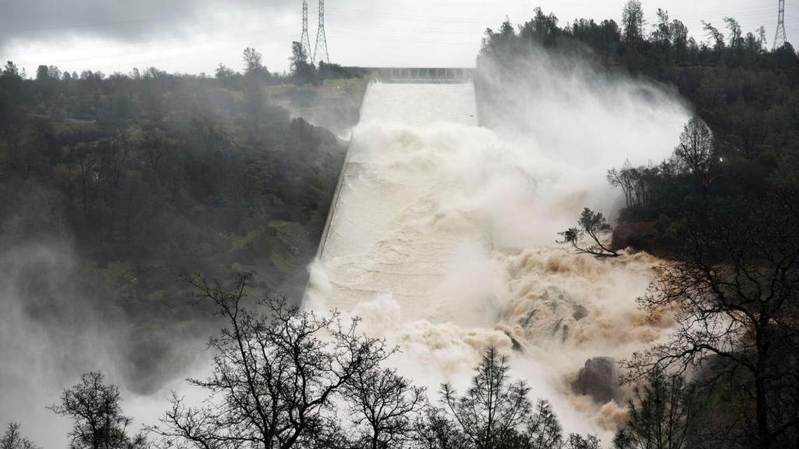 Water rushing down the damaged Oroville Dam spillway breaches the concrete sides and spreads out across the earthen face of the dam on Thursday, Feb. 9, 2017.