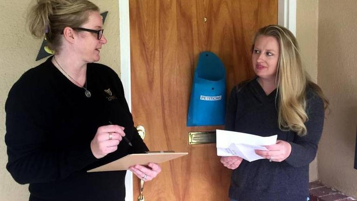 Lorraine Messerer, left, and Marissa Burt look at signed petitions Friday, April 7, 2017 that neighbors have left at Burt’s house. Messerer has been working with Burt to organize opposition to the latest rate hike.