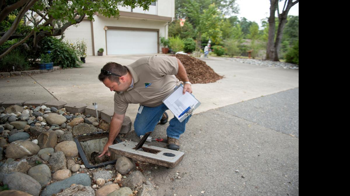 
Darren Van Dusen, a conservation technician with the San Juan Water District, checks a water meter for a customer in Granite Bay who was concerned about his water use. 
