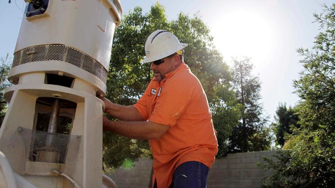
Micha Berry, with the city of Fresno’s water division, unscrews the motor that sits on top of a groundwater well in order to repair the well’s pump. Fresno, which has for decades relied exclusively on groundwater as a drinking water source for its residents, is one of many water users throughout central California that have seen a drop in their water table. California recently adopted new laws regulating groundwater withdrawal, but they do not take full effect for 25 years. .
