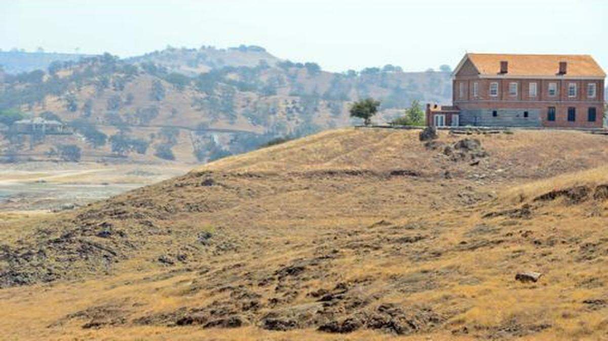 
Comparison photos showing the historic Millerton Courthouse as it sits atop a bluff overlooking Millerton Lake in Friant in 2009, top, with the water at a high point, and on Aug. 5, 2014, where the water isn’t visible at the same angle. Currently, the level of water is at 270,284 acre-feet, or 51.9 percent of capacity.
