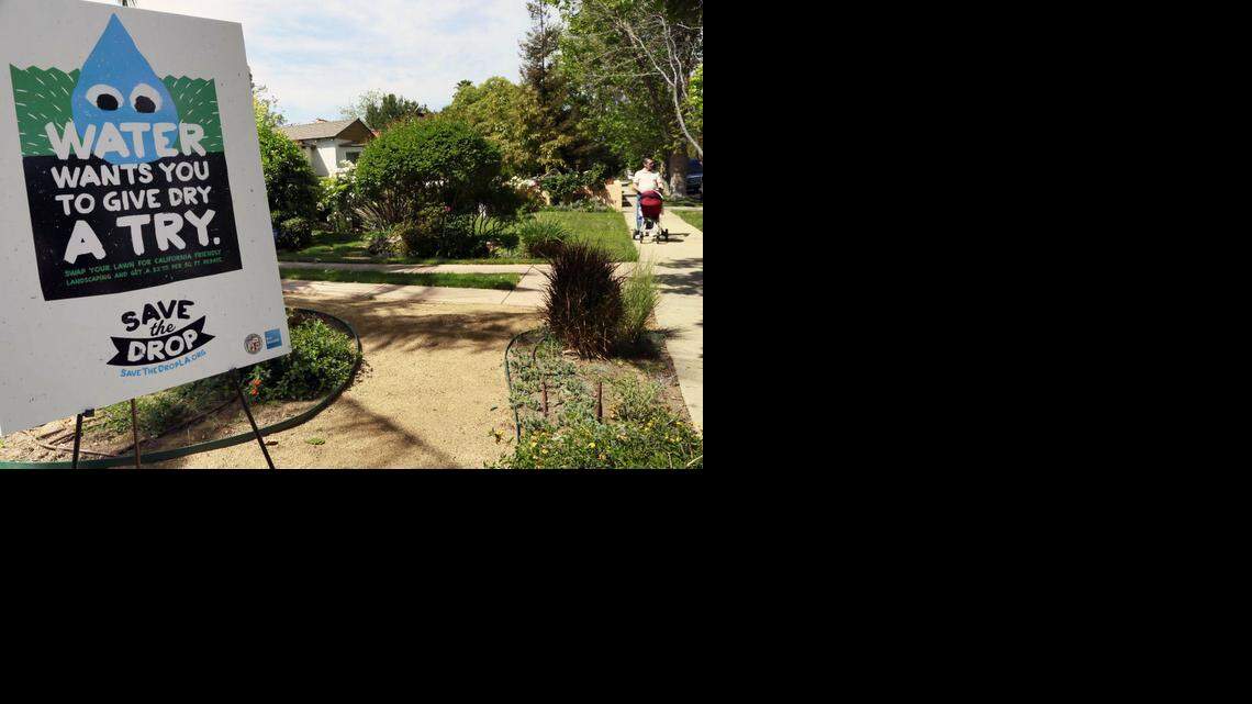 
A sign encouraging people to save water is displayed at a news conference in Los Angeles last week. A new report says that the drought is unlikely to have a significant economic impact. That could change if the drought drags on, it said.
