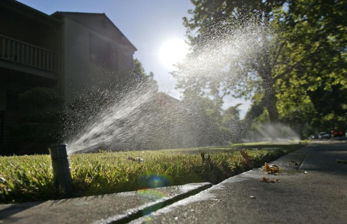 Sprinklers water grass at a home on July 1, 2014.