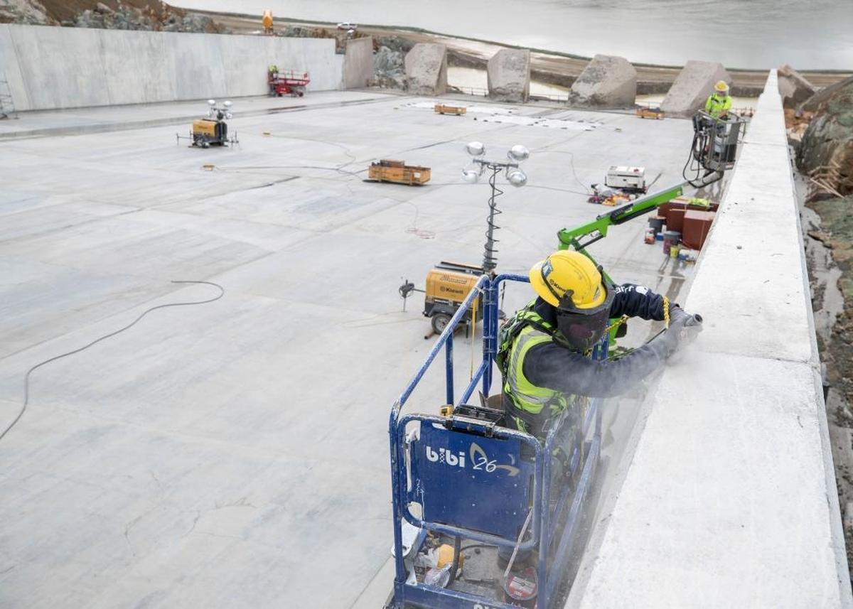 A worker from Kiewit Corp., the general contractor in charge of Oroville Dam repairs, cleans a joint between two rebuilt sidewall panels along the lower end of the main flood control spillway in November. The spillway will be used Tuesday for the first time since the February 2017 crisis.