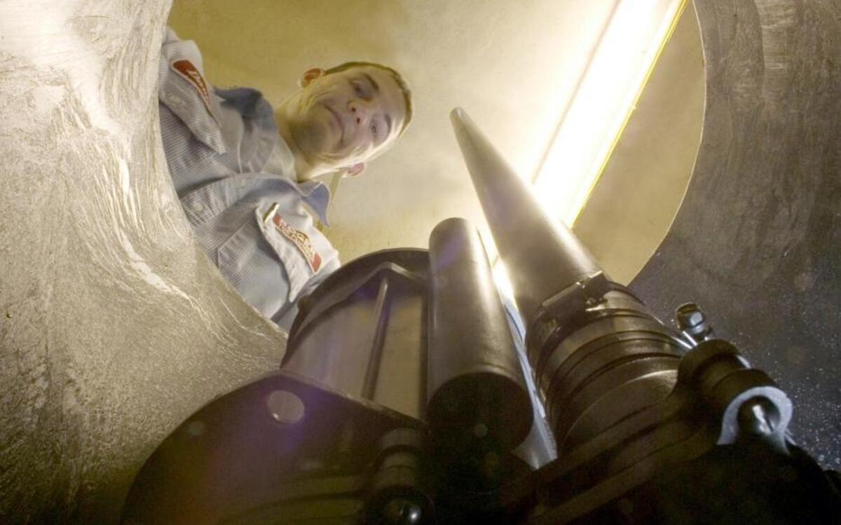 A technician works on a basement sump pump.