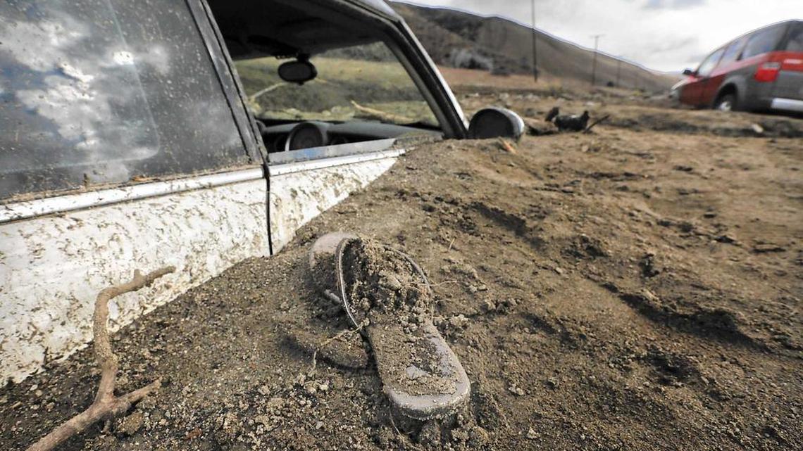 A sandal is left behind atop mounds of dirt where a Mini Cooper was buried during a mudslide in Elizabeth Lake.