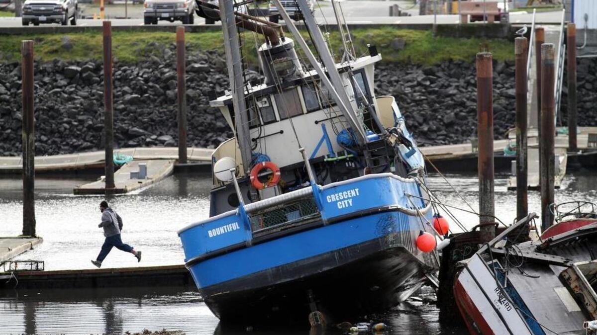An unidentified man runs from a boat as a surge of water makes its way towards the boat basin in Crescent City, Calif., on Friday, March 11, 2011. The tsunami triggered by the massive earthquake in Japan rushed onto California’s coast, causing powerful surges that destroyed boat docks, sent beach-area residents throughout the state evacuating to higher ground and swept at least one person out to sea.