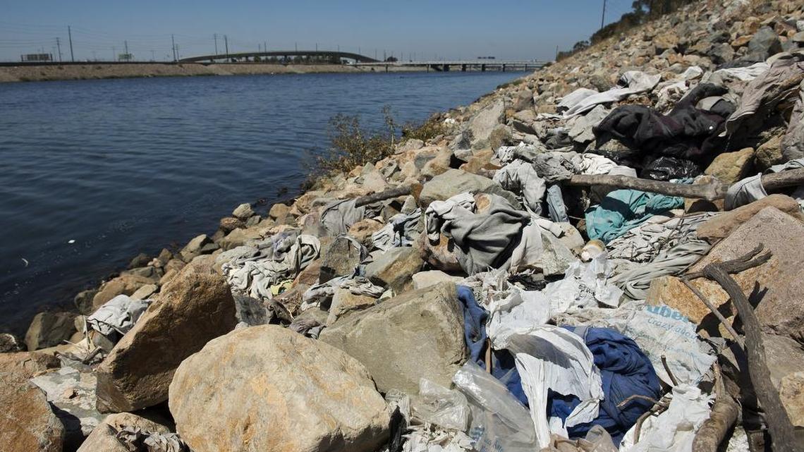 A large pile of washed-up trash, including old plastic bags, sits alongside the Los Angeles River in Long Beach, Calif. This week, Sacramento will join 145 other communities in California in banning single-use plastic bags from grocery stores, large pharmacies and other retailers.