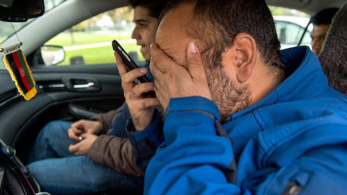 Afghan refugee Faisal Razmal, whose therapist says he suffers from post-traumatic stress disorder, talks on his cellphone to a fellow Afghan who also suffers from PTSD. In the front seat is Khyber Hussain Khil, 29, who came to Sacramento to support Razmal when he feared he was suicidal. In the back is Pasoon Khan, 24, who says he also has PTSD after being shot twice in his arm and sprayed with shrapnel during the war.